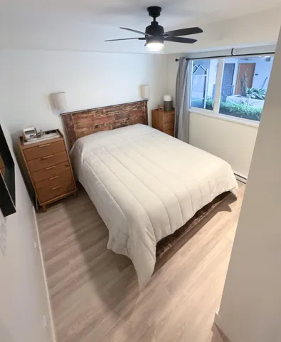 Wood-finish flooring with a modern ceiling fan and recessed lighting