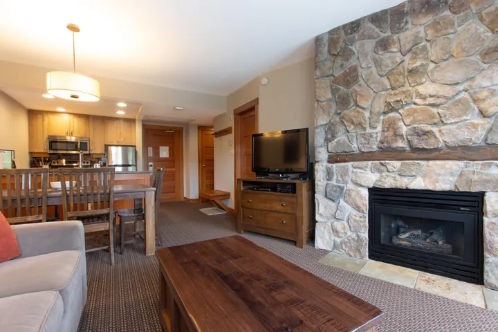 Carpeted living area featuring a fireplace, baseboards, and recessed lighting
