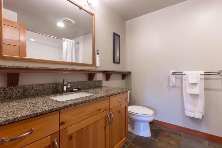 Bathroom with baseboards, vanity, toilet, and curtained shower