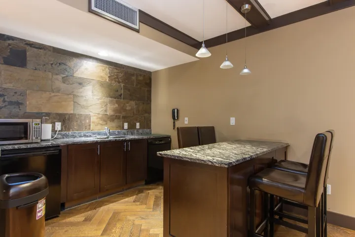 Bar with stainless steel microwave, dishwasher, pendant lighting, and a sink