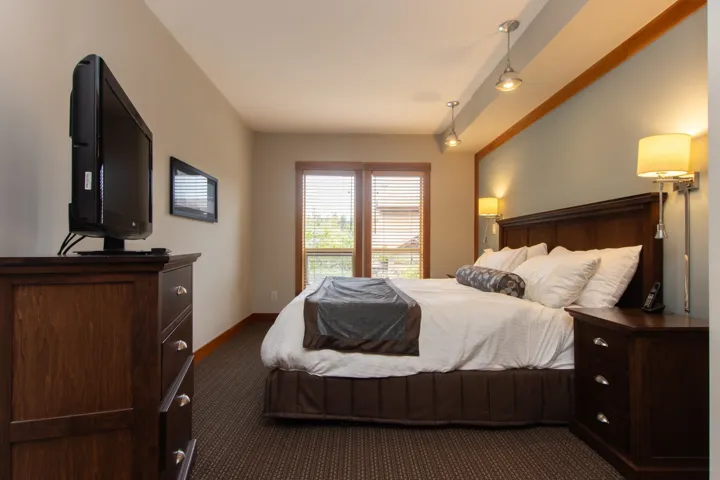 Bedroom with dark colored carpet, baseboards, and track lighting