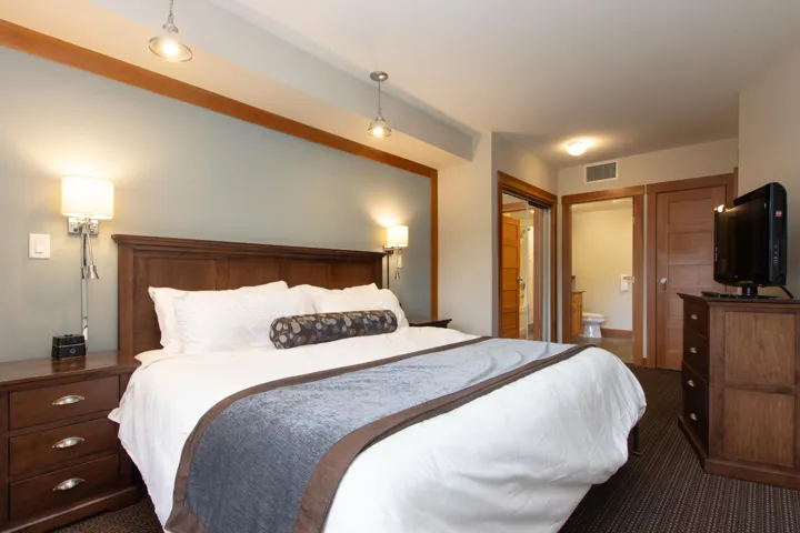 Bedroom featuring dark carpet and connected bathroom