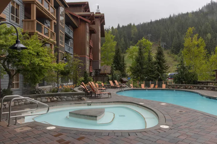 Community pool featuring a forest view and a patio area