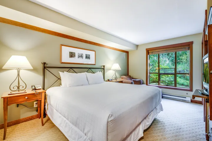 Bedroom with baseboard heating and light colored carpet