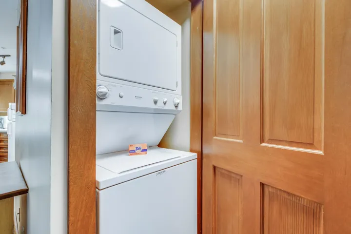 Laundry room featuring stacked washing machine and dryer