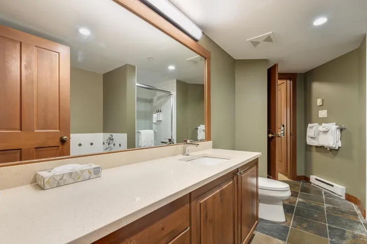 Bathroom with a baseboard heating unit, vanity, a stall shower, recessed lighting, and stone tile floors
