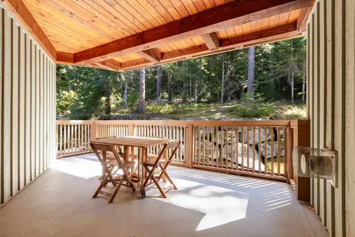 Wooden terrace with outdoor dining area and a patio area