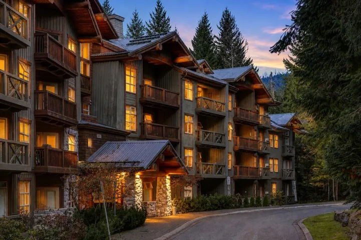 Multi-story building featuring natural wood siding and stone accents