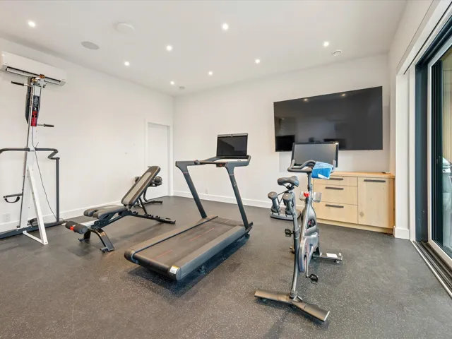 Exercise area featuring recessed lighting, a wall mounted AC, and dark rubber floors