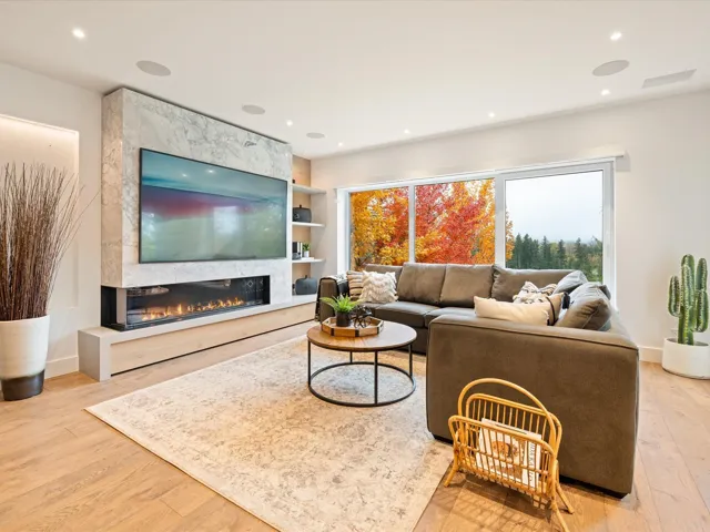 Living area featuring a high end fireplace, light wood-style floors, and recessed lighting