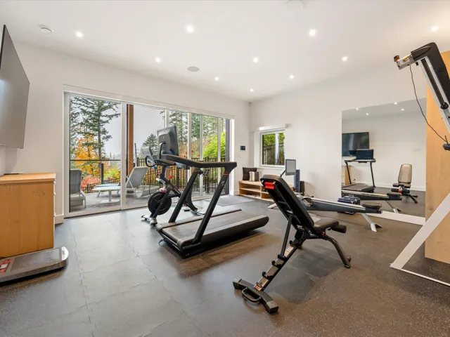 Exercise area with recessed lighting and dark rubber floors