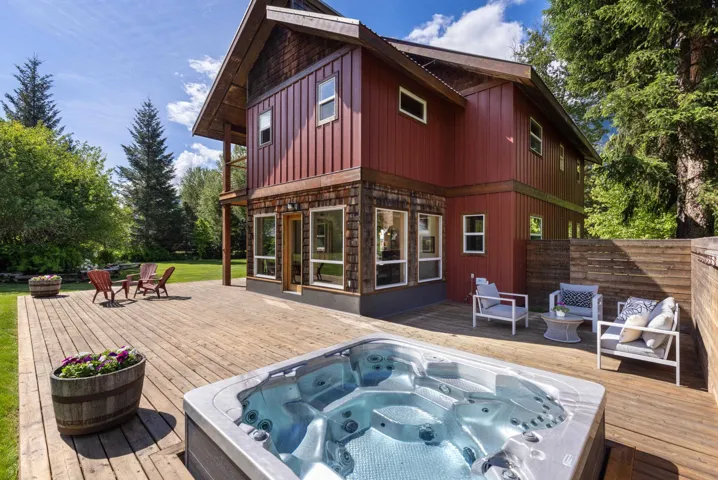 Expansive wood deck with a built-in spa, a privacy fence, and direct access to the red-sided dwelling