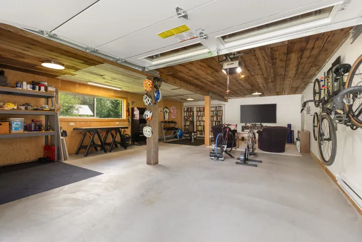 Spacious garage featuring a concrete floor, wood plank ceiling, and a large window