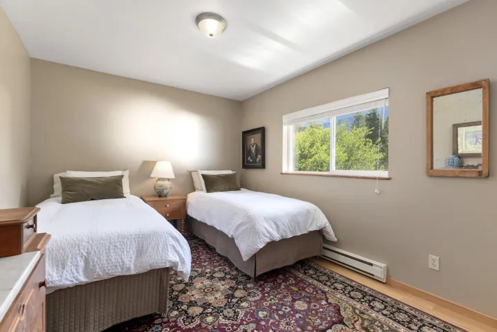 Carpeted floor with wood-finish perimeter, neutral wall tones, and a large window with natural light