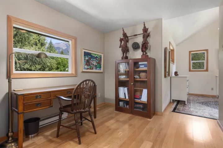 Neutral-toned walls enhance the natural light in this space, featuring wood-finish flooring and a natural wood trim window frame