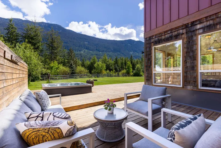 Expansive wooden deck featuring an outdoor spa and ample space for seating