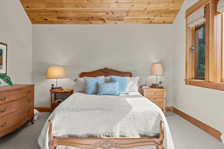 Bedroom featuring a plank wood ceiling, light-toned wall paint, and carpet flooring
