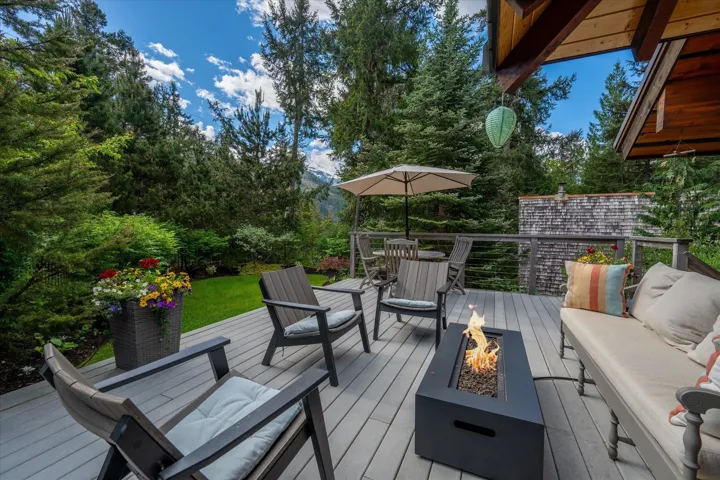 Expansive outdoor deck featuring composite decking, cable railing, and a built-in fire pit