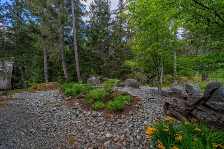 Gravel pathway bordered by natural boulders and verdant landscaping