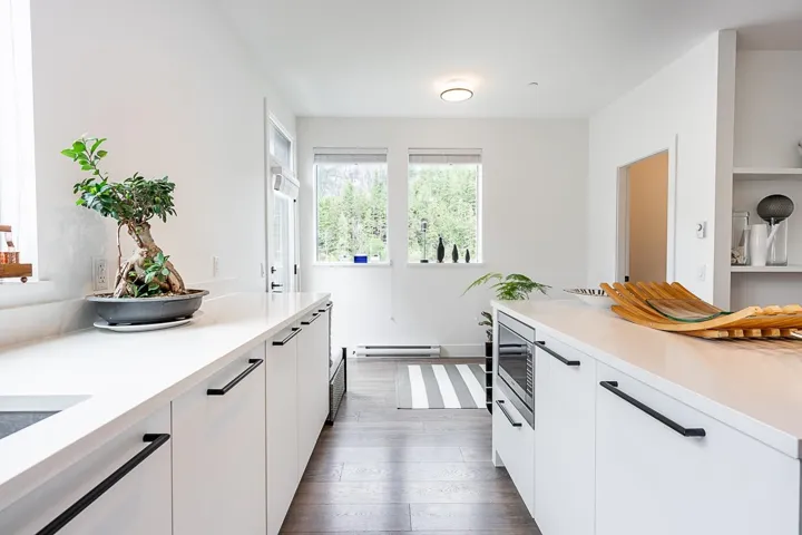 Kitchen featuring white cabinetry, light countertops, dark wood-type flooring, and modern cabinets