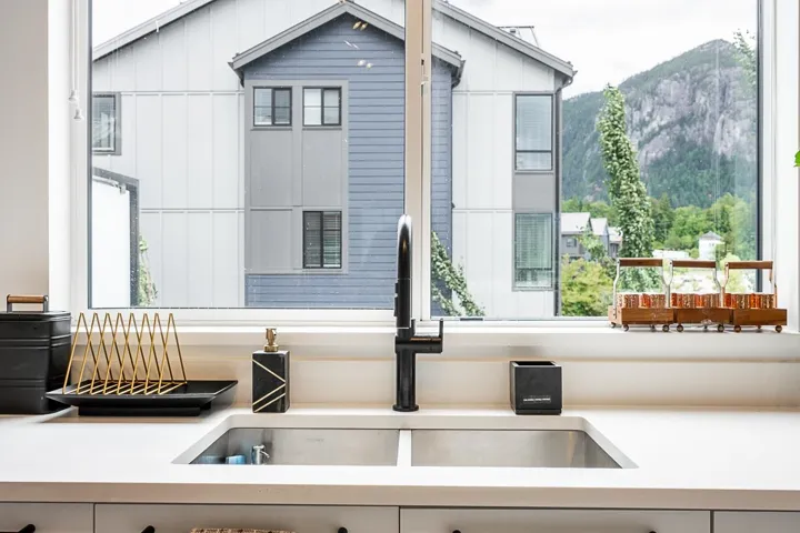 Kitchen view of a mountain backdrop and light stone counters
