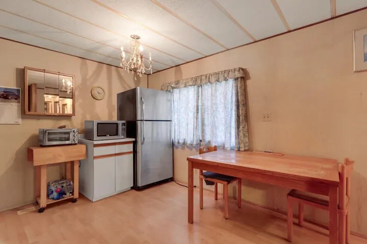 Kitchen featuring light wood finished floors, a chandelier, and stainless steel appliances