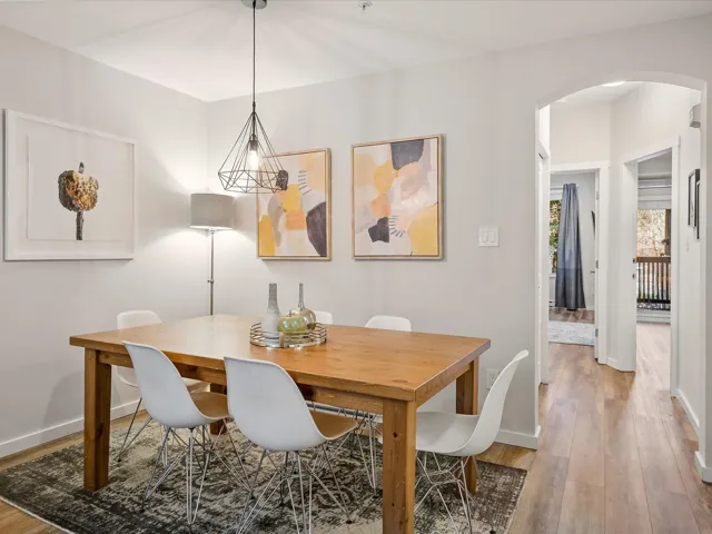 Dining room featuring arched walkways and light wood-style flooring