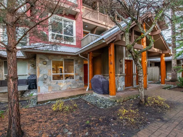 View of exterior entry featuring stone siding and a metal roof
