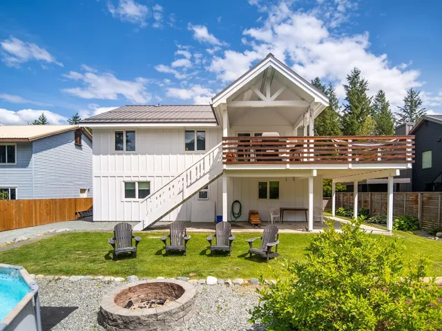 Rear view of house featuring an outdoor fire pit, board and batten siding, a metal roof, a patio, and stairs
