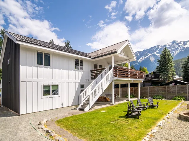 Rear view of property with stairs, a deck with mountain view, board and batten siding, and a metal roof