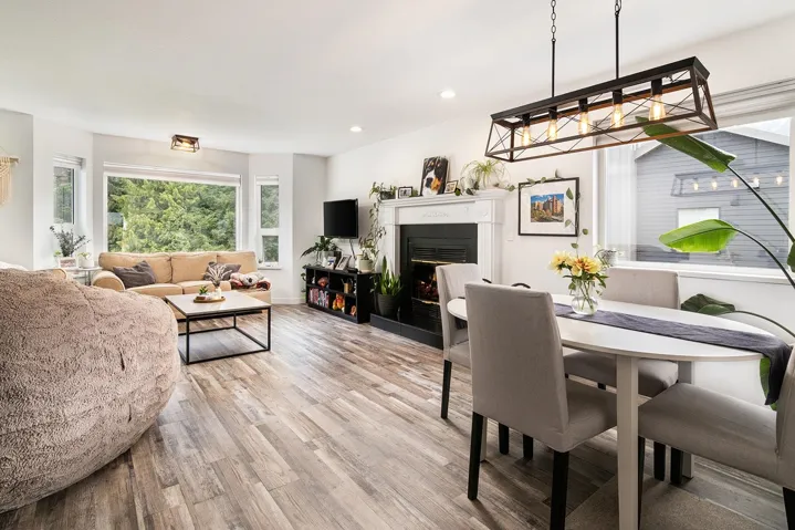 Dining area with light wood-type flooring, a lit fireplace, and recessed lighting