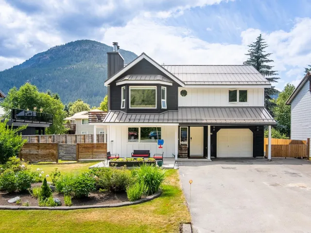 View of front facade featuring a standing seam roof, board and batten siding, a mountain view, a metal roof, and a chimney