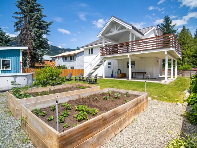 Rear view of house featuring a garden, stairs, a deck, a patio area, and board and batten siding