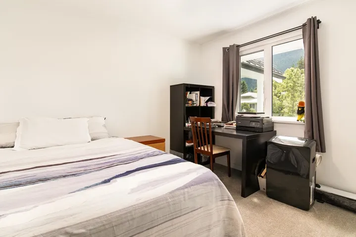 Carpeted bedroom featuring ornamental molding and an office area