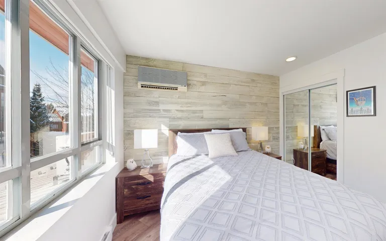 Bedroom featuring wooden walls, wood finished floors, recessed lighting, a closet, and a baseboard heating unit
