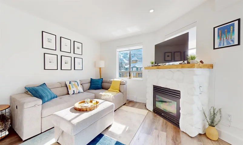 Living area featuring wood finished floors and a stone fireplace