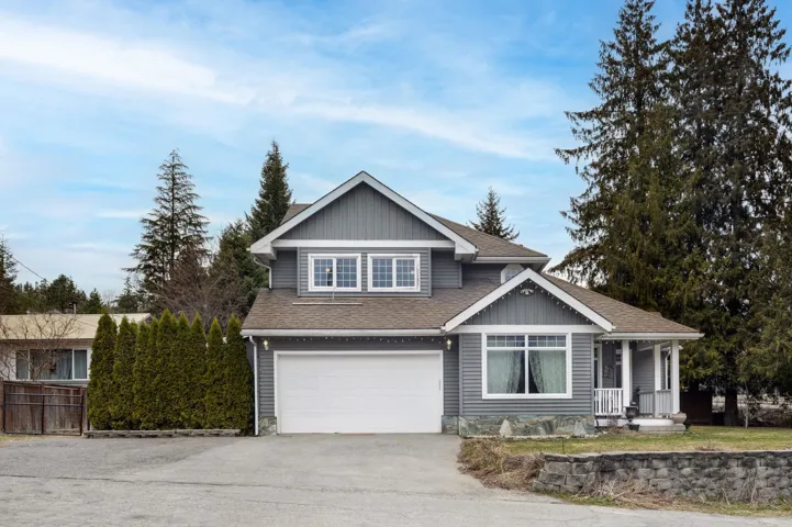 View of front of property with aphalt driveway, a shingled roof, covered porch, an attached garage, and fence