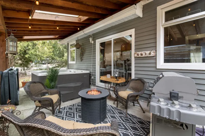 View of patio / terrace with a fire pit, a hot tub, and a grill
