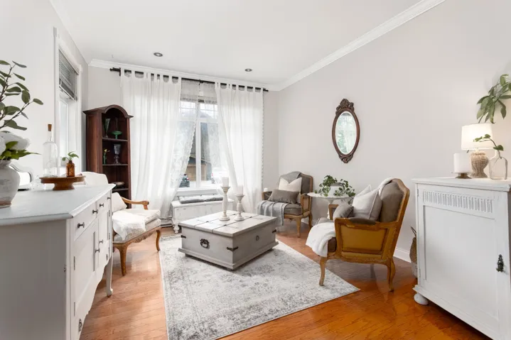 Living area with baseboards, crown molding, and light wood finished floors
