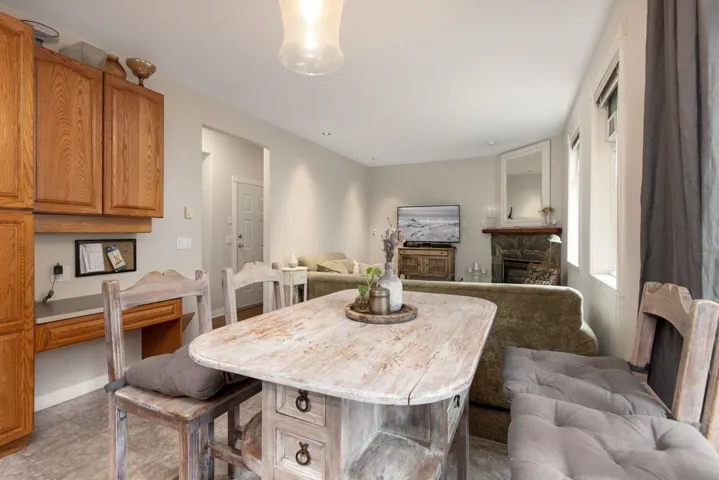Dining area featuring light tile patterned floors, baseboards, and a fireplace