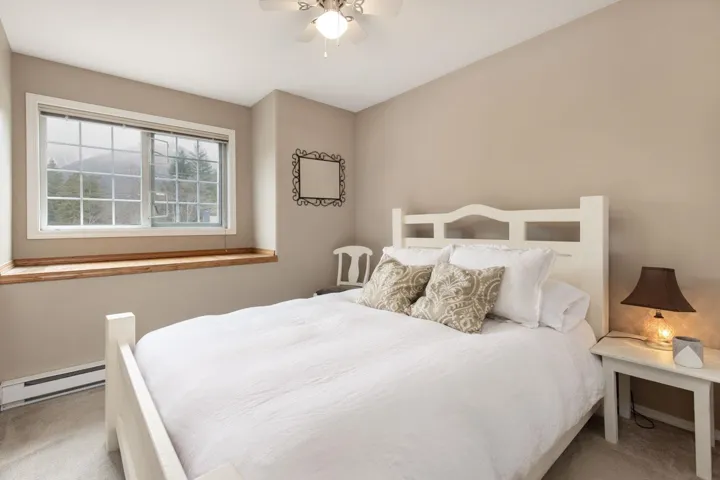 Bedroom featuring a baseboard heating unit, carpet floors, and a ceiling fan