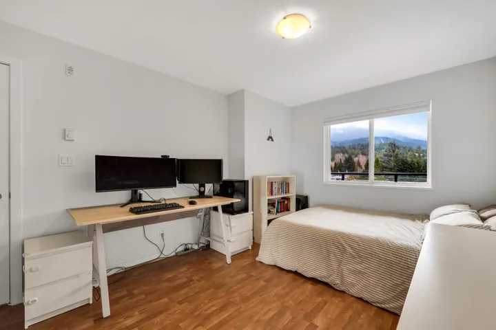 Bedroom featuring wood finished floors and an office area