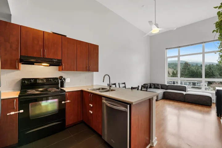 Kitchen featuring black / electric stove, open floor plan, dishwasher, decorative backsplash, and light countertops