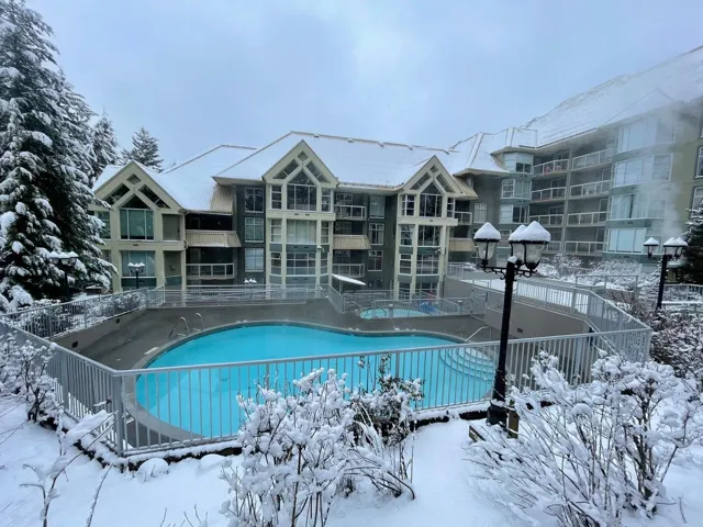 Snow covered pool with a patio and a community pool
