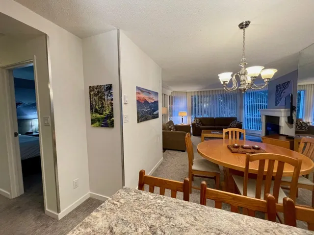 Dining space featuring baseboards, carpet, an inviting chandelier, and a textured ceiling
