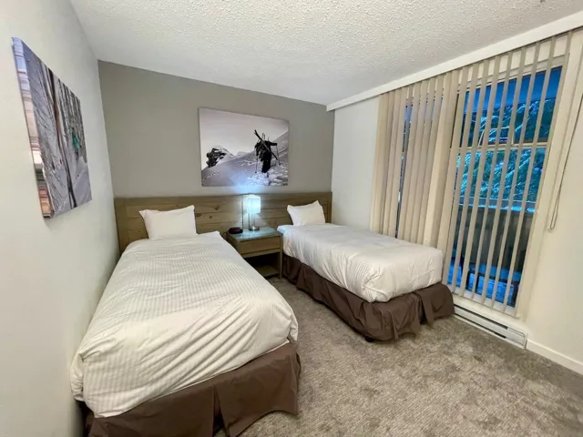 Carpeted bedroom with baseboard heating and a textured ceiling