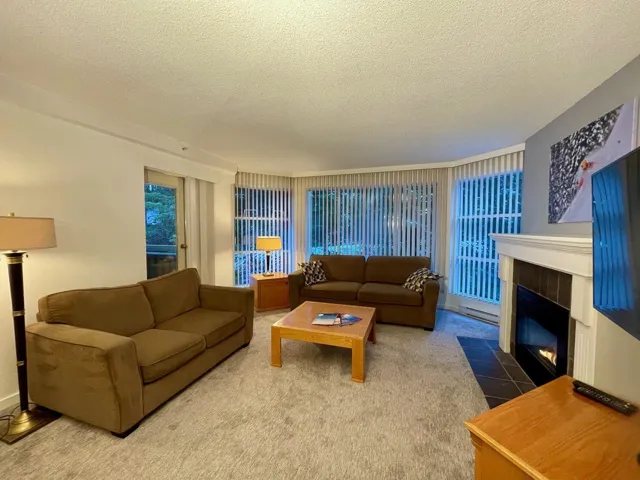 Living area with a textured ceiling and a tiled fireplace