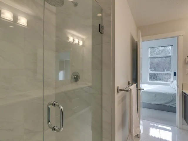 Full bathroom with a shower stall, connected bathroom, a textured ceiling, and tile patterned flooring