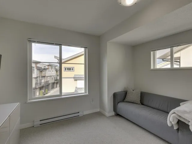 Living area with baseboard heating and light carpet