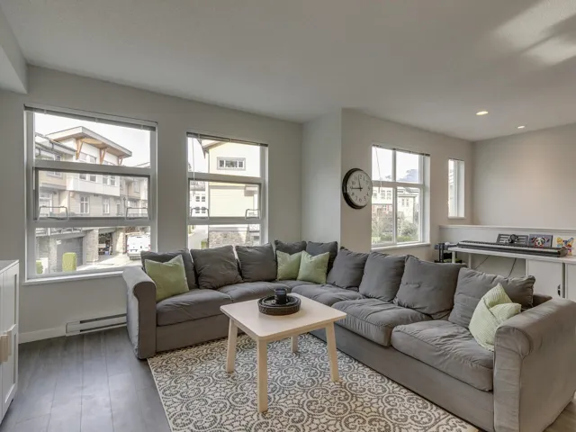 Living area featuring wood finished floors, a baseboard radiator, and recessed lighting
